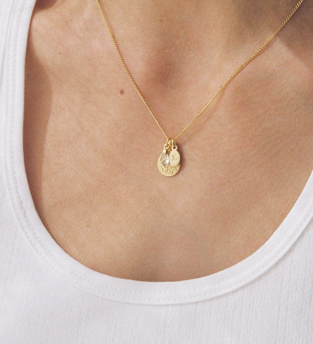 Gold necklace with gold initial charm, crystal charm and coin charm