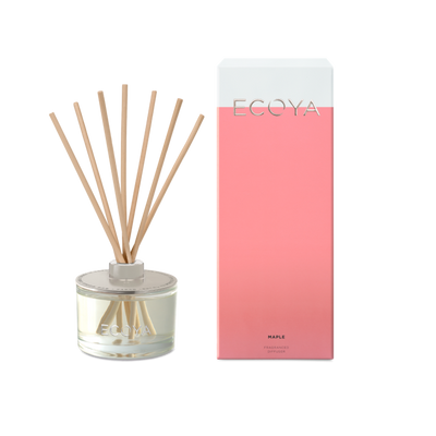 Ecoya reed diffuser with glass bottle and reeds next to a pink box