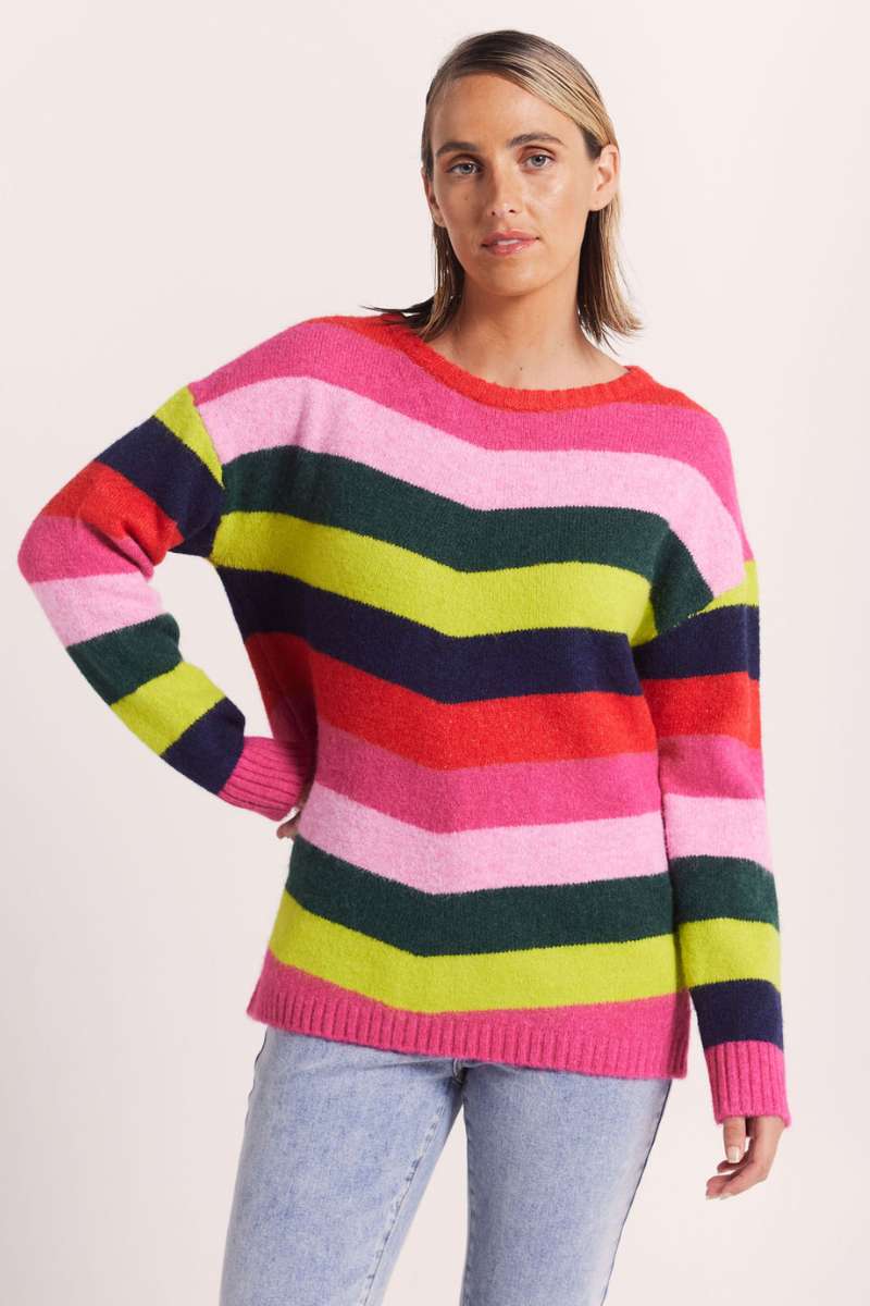 Woman wearing bright pink green and blue striped sweater