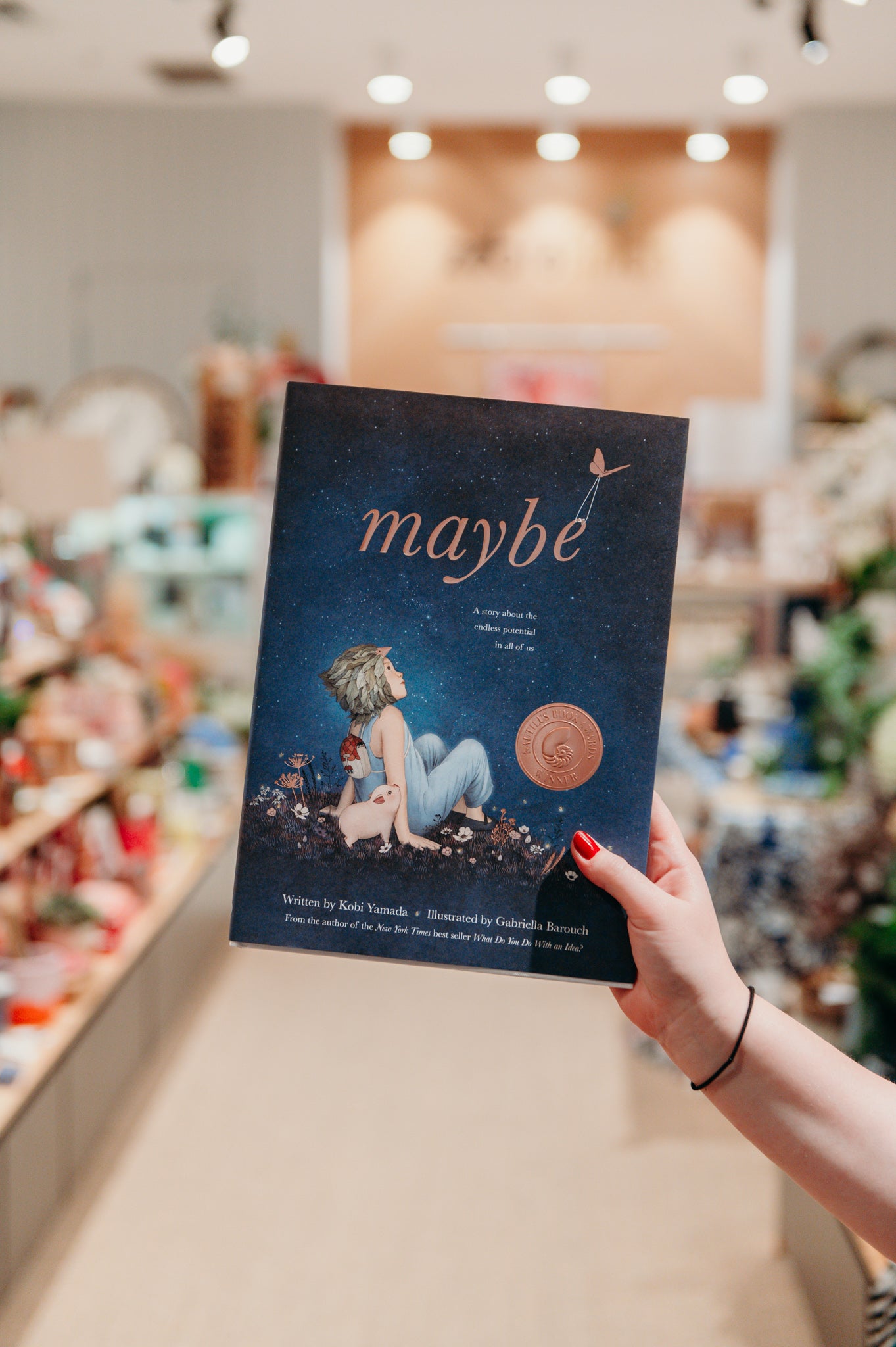 Children's book called Maybe that has a child sitting next to a pig on the front cover, looking up at the night sky.