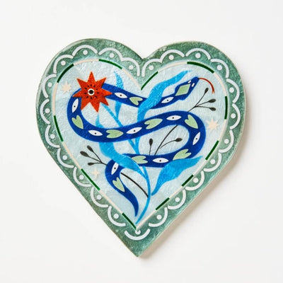 Heart-shaped decorative item with a blue snake and red flower design on a white background