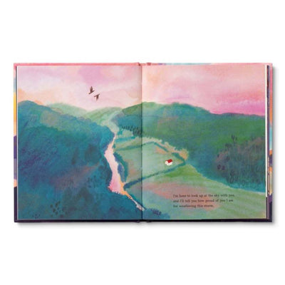 Open book with a colorful landscape illustration on a white background