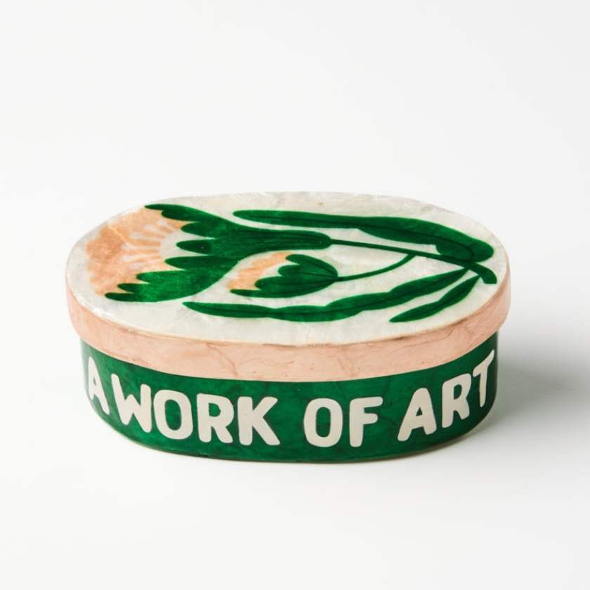 Round decorative container with floral design and 'A Work of Art' text on a white background