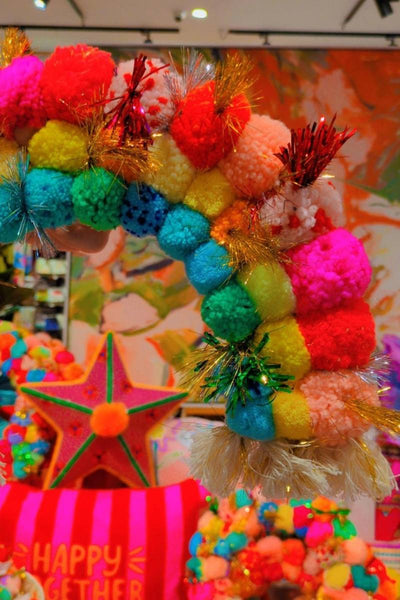 Colorful pom-pom rainbow with a star decoration against an abstract background | Pom pom rainbow by Arissa Lifestyle available at Zebra Finch Style in Newcastle, NSW
