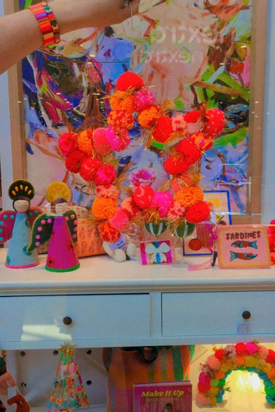 Colourful display with decorative items including a star made of pom-poms | Arissa star pom pom wreaths available at Zebra Finch Style in Newcastle, NSW