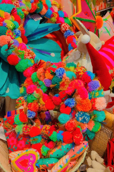 Colourful display with decorative items including a star made of pom-poms | Arissa star pom pom wreaths available at Zebra Finch Style in Newcastle, NSW