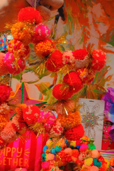 Colourful display with decorative items including a star made of pom-poms | Arissa star pom pom wreaths available at Zebra Finch Style in Newcastle, NSW