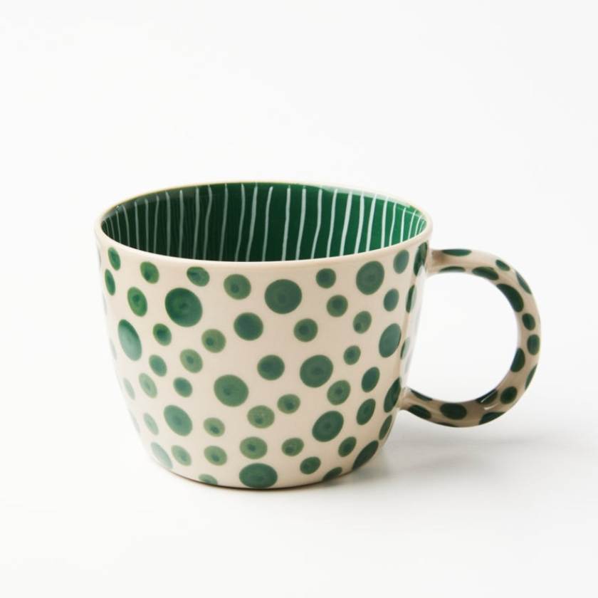 Green polka dot mug on a white background
