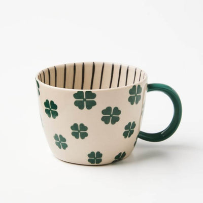 Mug with clover pattern and green handle on a white background