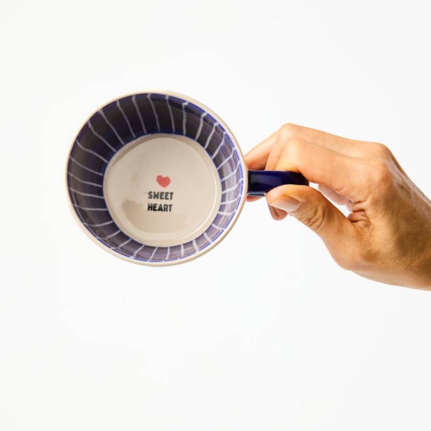 Hand holding a mug with 'Sweet Heart' text and heart design on a white background