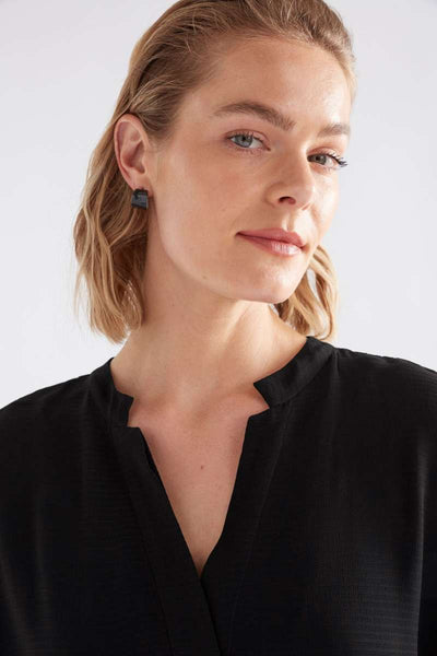 Woman wearing a black top against a white background, featuring Navy earrings on a white background. Illsta Mini Hoop earrings by Elk the Label. ELK stockist in Newcastle at Zebra Finch Style