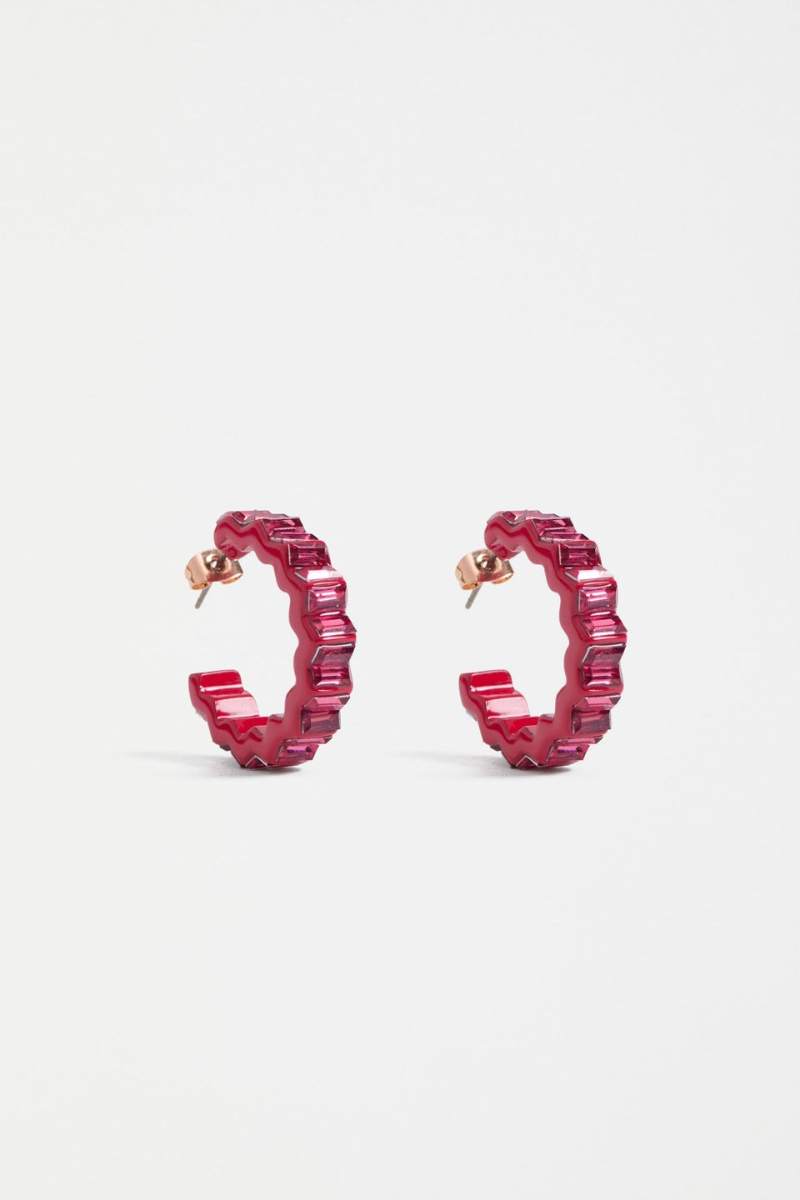 Pair of red hoop earrings on a light gray background