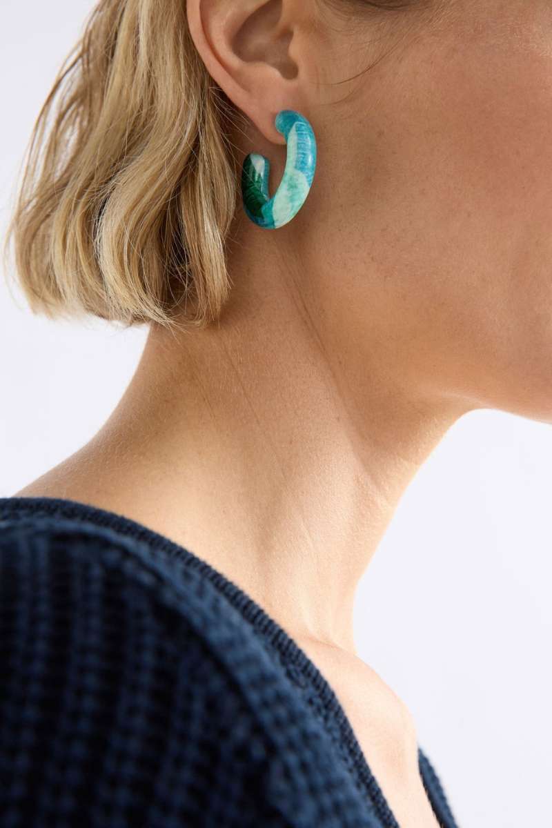 Close-up of a person wearing turquoise hoop earrings with a neutral background. Resso Hoop Earring by ELK the Label. ELK Stockist in Newcastle, NSW at Zebra Finch Style