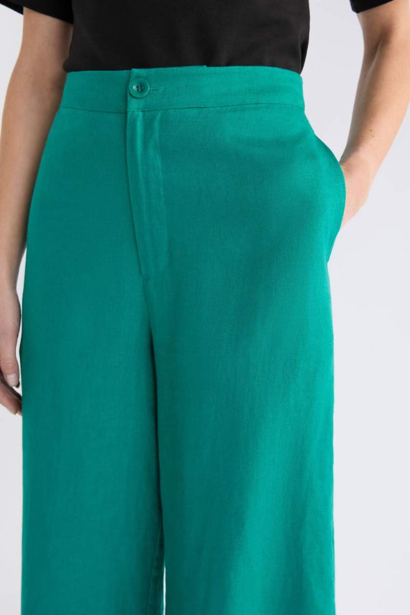 Teal pants worn by a person on a white background