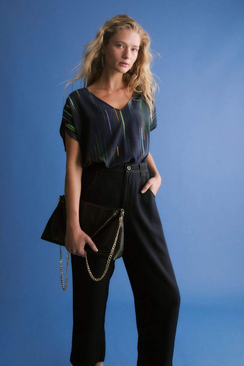 Woman wearing a black outfit with a blue background