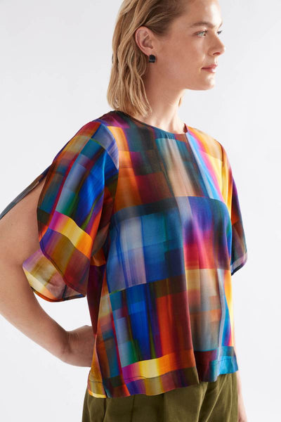 Woman wearing a colorful geometric patterned top against a white background by Elk the Label | Elk Stockist in Newcastle at Zebra FInch Style