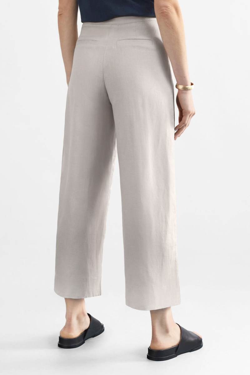 Woman wearing a blue top and light flax coloured pants on a white background y Elk the Label | Elk Stockist in Newcastle, NSW at Zebra FInch Style