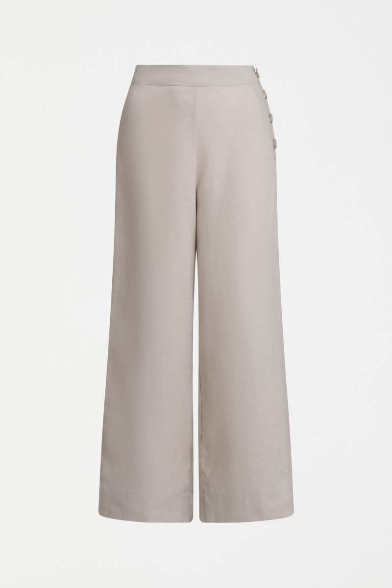 Woman wearing a blue top and light flax coloured pants on a white background y Elk the Label | Elk Stockist in Newcastle, NSW at Zebra FInch Style