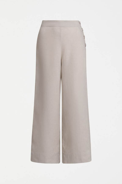 Woman wearing a blue top and light flax coloured pants on a white background y Elk the Label | Elk Stockist in Newcastle, NSW at Zebra FInch Style