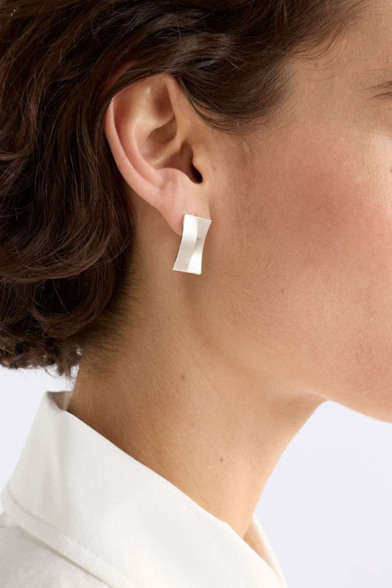 Close-up of a person wearing a silver earring with a plain background - Trel Stud Earrings by Elk The Label. ELK Stockist in Newcastle, NSW at Zebra Finch Style