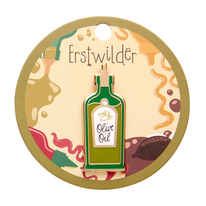 Enamel pin shaped like an olive oil bottle with a label on a white background - from Erstwilder's 2025 Condiments collection