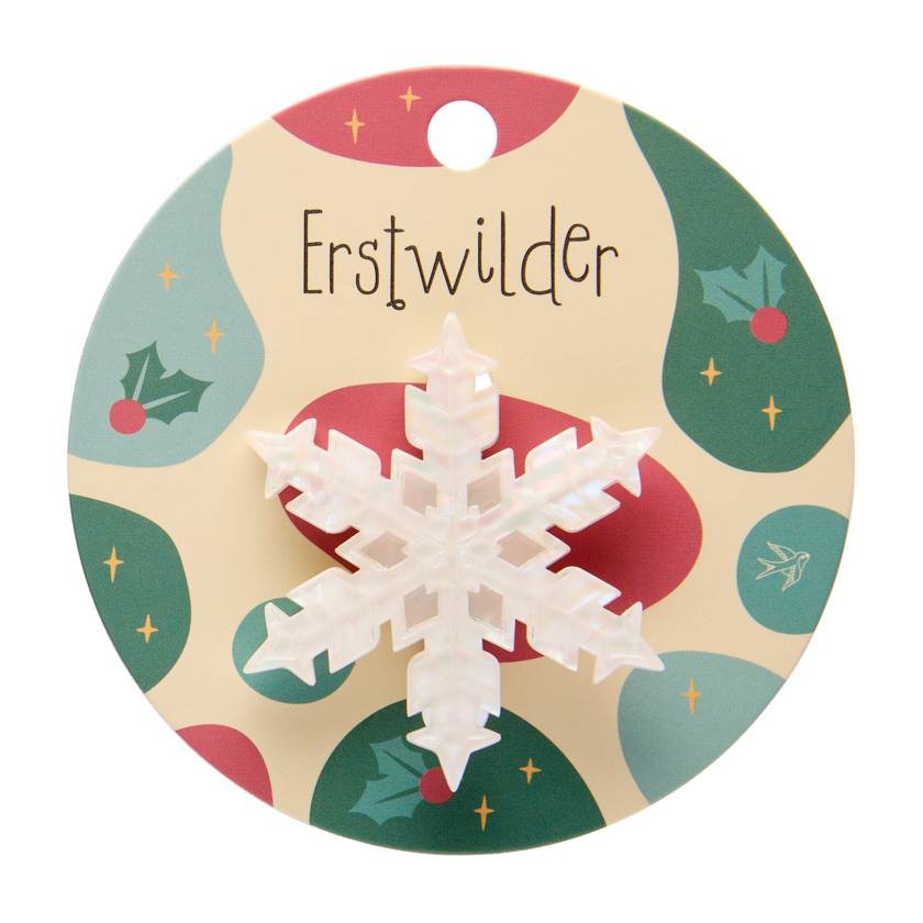 Iridescent snowflake-shaped brooch on a white background by Erstwildee
