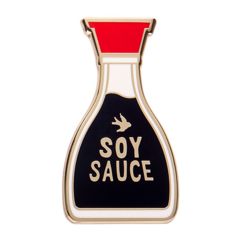 Pin shaped like a soy sauce bottle with red cap and black body on a white background. Erstwilder's soy sauce brooch from their 2025 condiments collection