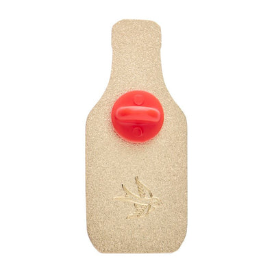 Enamel pin shaped like a tomato ketchup bottle with a logo on a white background. Erstwilder's Tomato sauce enamel pin from their 2025 Condiments collection
