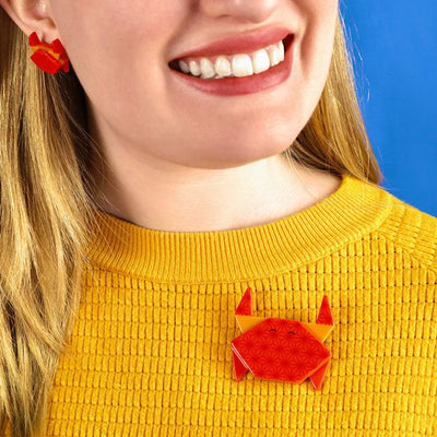 The Good Crab brooch on model's jumper by Erstwilder, from their 2023 Origami collection