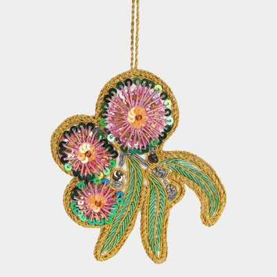 Decorative flower ornament with gold, pink, and green colors on a white background