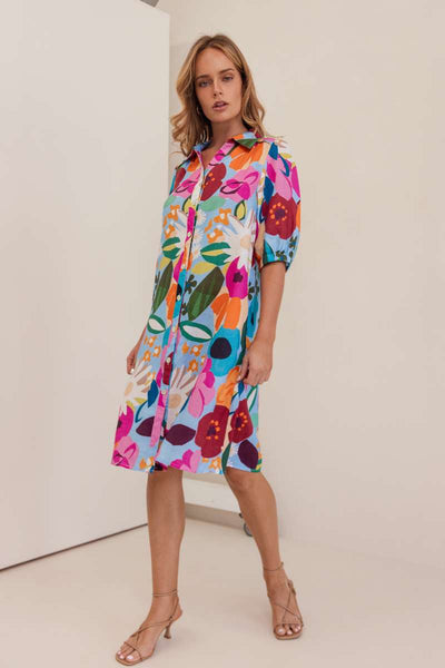 Woman wearing a colourful floral dress against a white background. Dress by Kaleido. Kaleido stockist at Zebra FInch Style in Newcastle, NSW