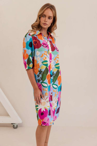 Woman wearing a colourful floral dress against a white background. Dress by Kaleido. Kaleido stockist at Zebra FInch Style in Newcastle, NSW