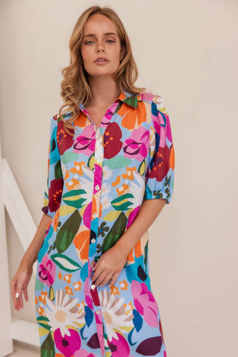 Woman wearing a colourful floral dress against a white background. Dress by Kaleido. Kaleido stockist at Zebra FInch Style in Newcastle, NSW