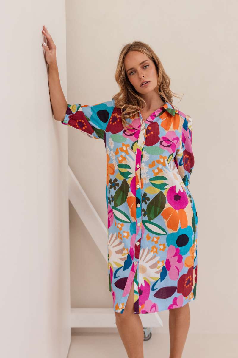 Woman wearing a colourful floral dress against a white background. Dress by Kaleido. Kaleido stockist at Zebra FInch Style in Newcastle, NSW