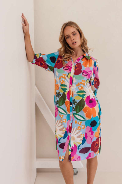 Woman wearing a colourful floral dress against a white background. Dress by Kaleido. Kaleido stockist at Zebra FInch Style in Newcastle, NSW