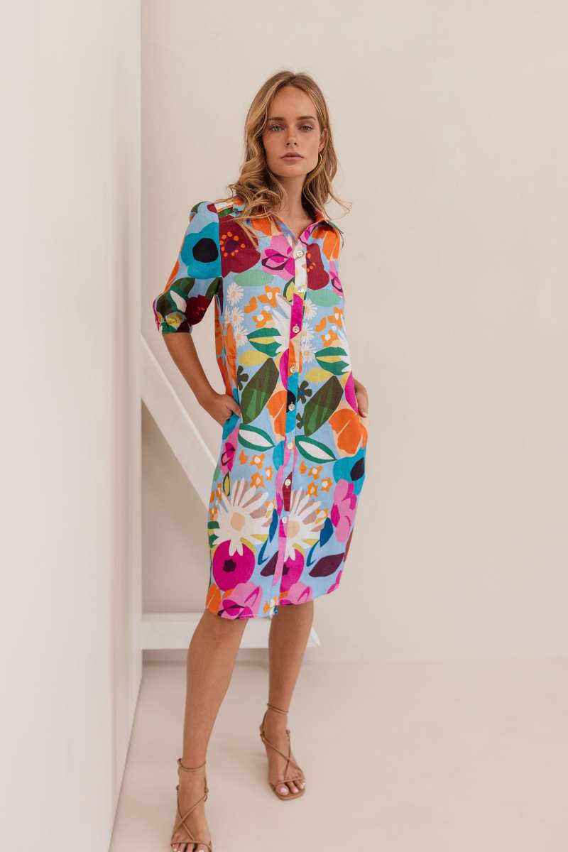 Woman wearing a colourful floral dress against a white background. Dress by Kaleido. Kaleido stockist at Zebra FInch Style in Newcastle, NSW