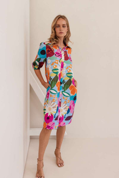 Woman wearing a colourful floral dress against a white background. Dress by Kaleido. Kaleido stockist at Zebra FInch Style in Newcastle, NSW