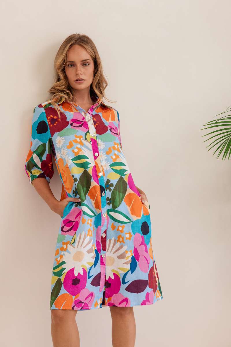 Woman wearing a colourful floral dress against a white background. Dress by Kaleido. Kaleido stockist at Zebra FInch Style in Newcastle, NSW