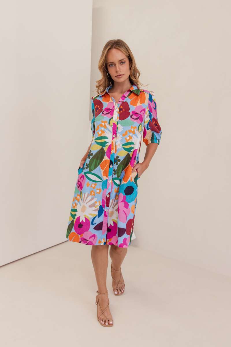 Woman wearing a colourful floral dress against a white background. Dress by Kaleido. Kaleido stockist at Zebra FInch Style in Newcastle, NSW
