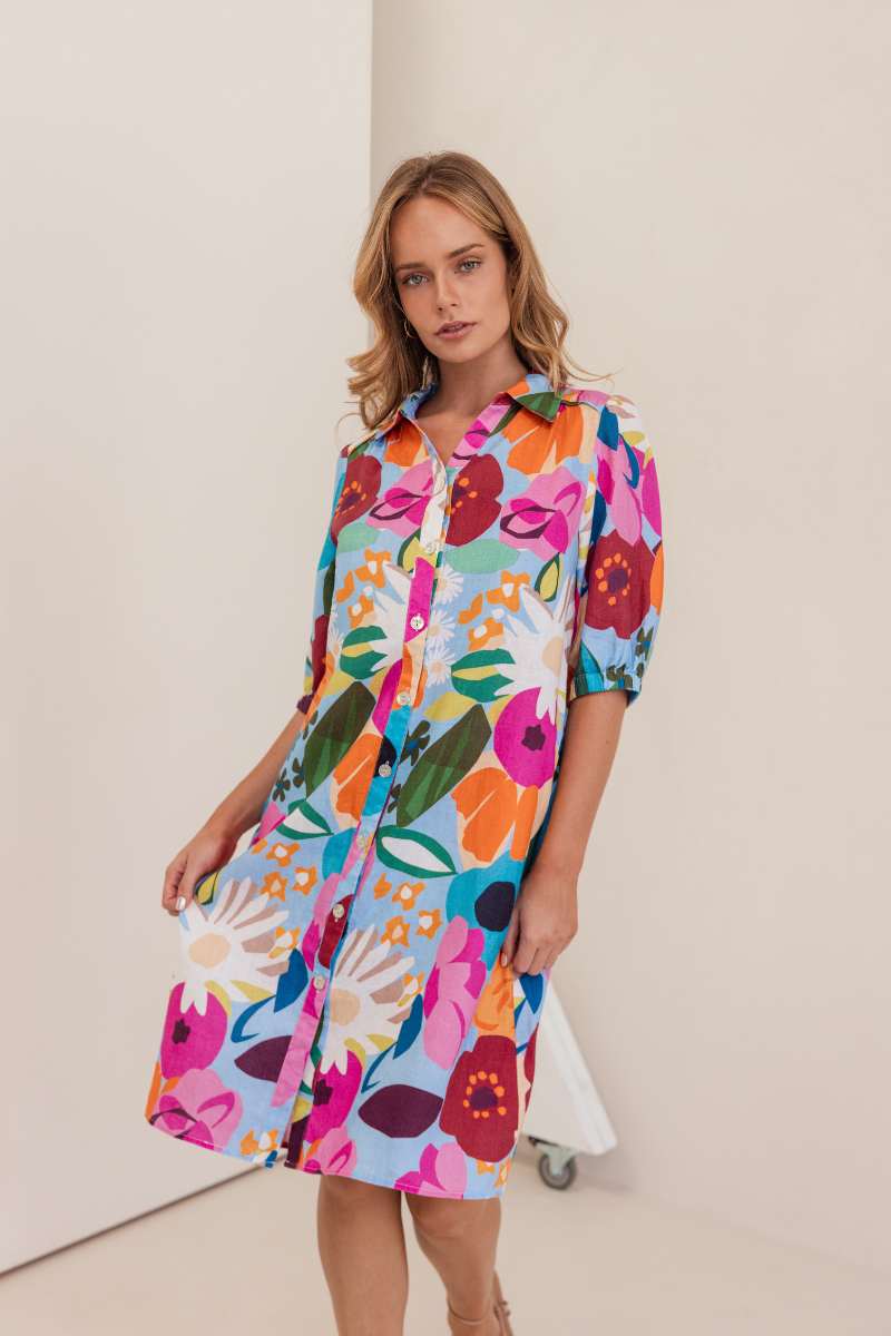 Woman wearing a colourful floral dress against a white background. Dress by Kaleido. Kaleido stockist at Zebra FInch Style in Newcastle, NSW