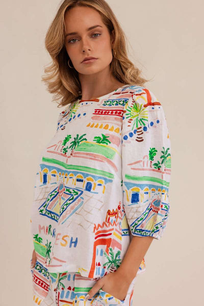 Woman wearing a colorful patterned dress against a beige background by Kaleido