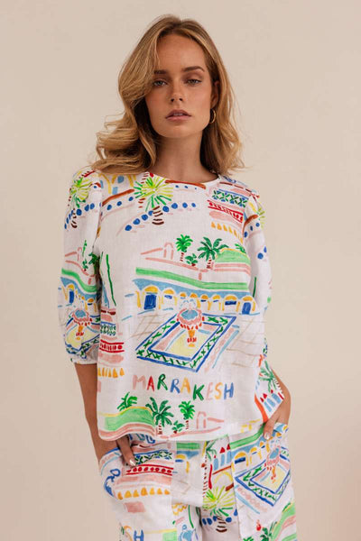 Woman wearing a colorful patterned dress against a beige background by Kaleido