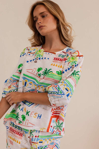 Woman wearing a colorful patterned dress against a beige background by Kaleido