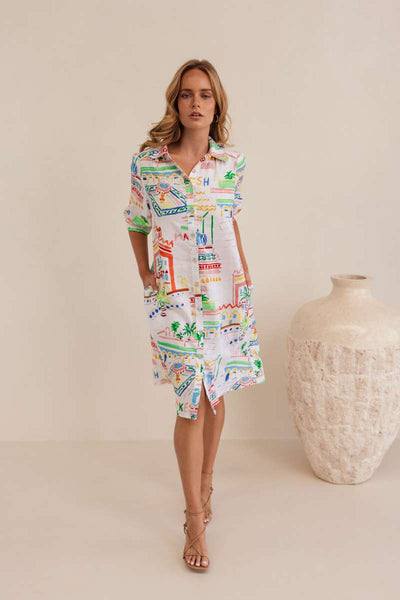 Woman wearing a colourful patterned dress against a neutral background, dress by Kaleido