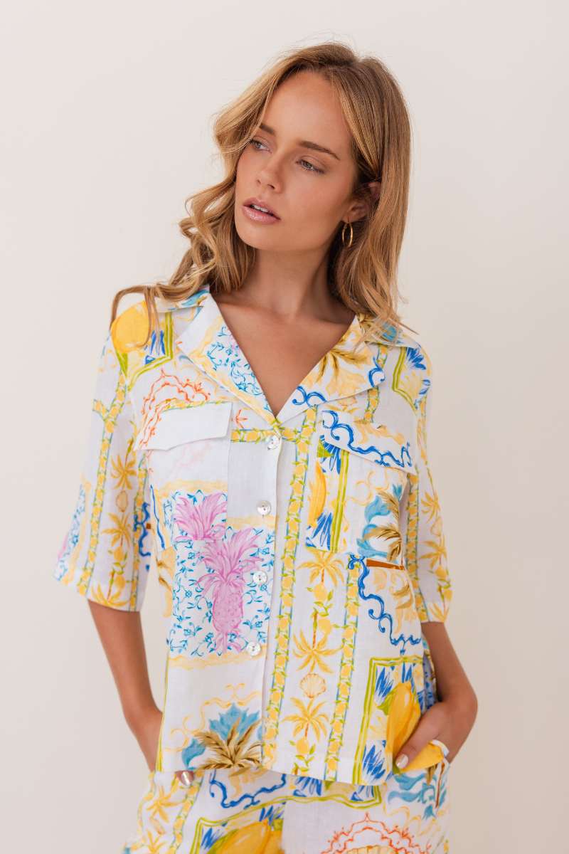 Woman wearing a colourful floral blouse against a plain background, by Kaliedo