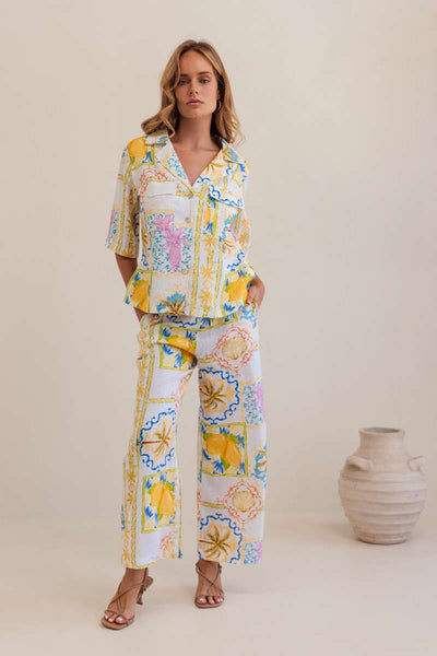 Woman wearing a colourful floral blouse against a plain background, by Kaliedo