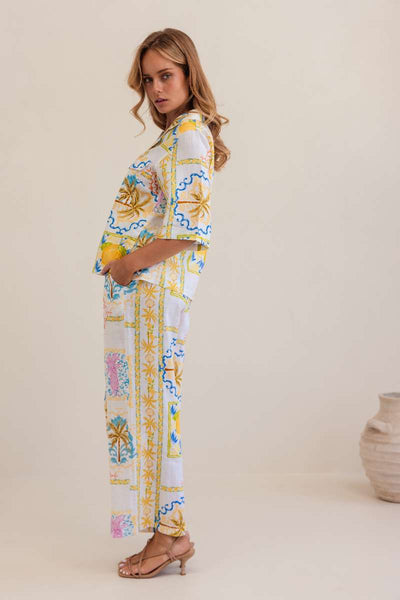 Woman wearing a colourful floral blouse against a plain background, by Kaliedo