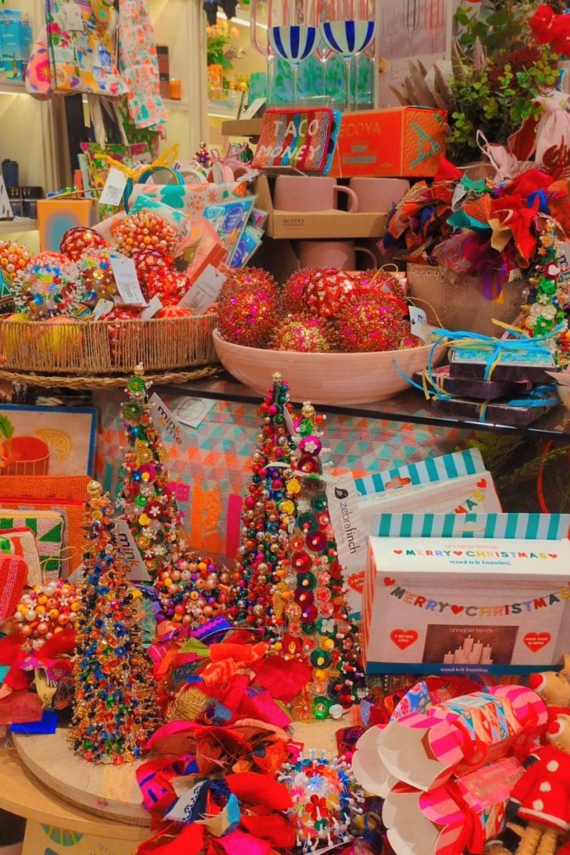 Colorful Christmas decorations and gift bags on a table with a festive atmosphere.