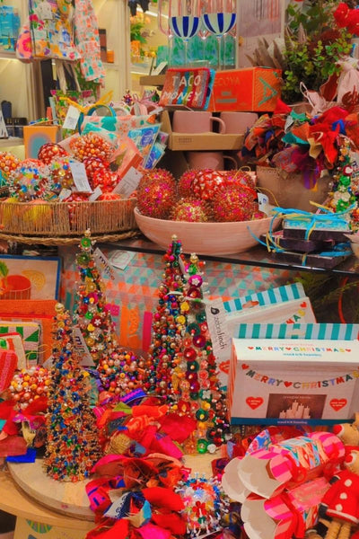 Colorful Christmas decorations and gift bags on a table with a festive atmosphere.