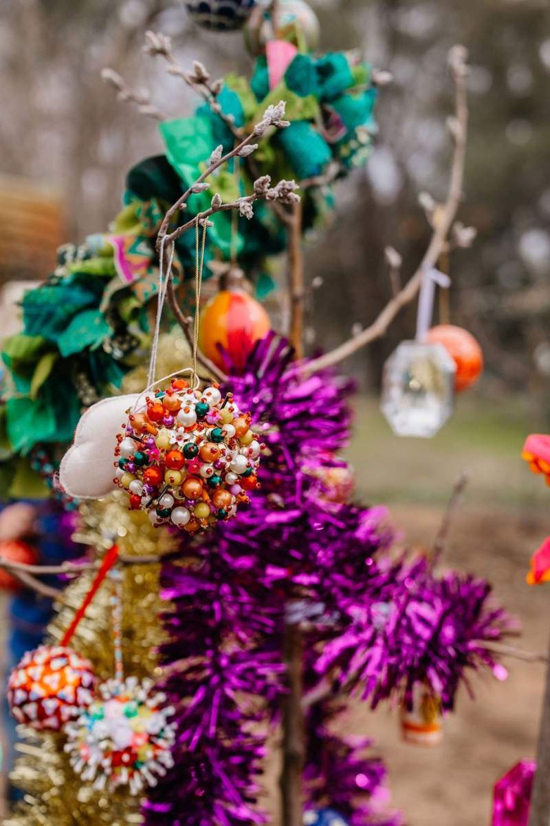 Decorative tree with colorful ornaments and tinsel against a natural background